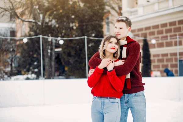 Coppia carina e amorevole in maglioni rossi in una città invernale — Foto Stock