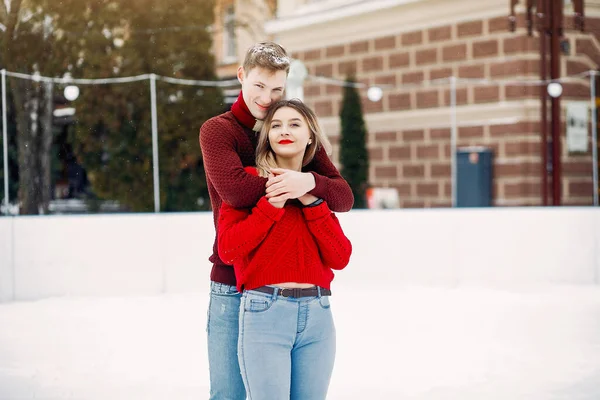 Kış şehrinde kırmızı kazaklar içinde sevimli ve sevgi dolu bir çift. — Stok fotoğraf