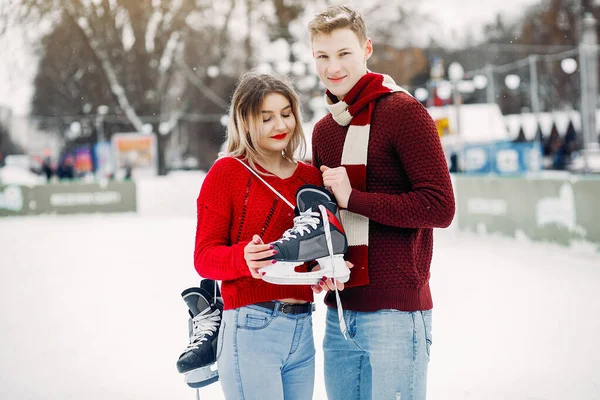 Casal bonito em uma camisola vermelha se divertindo em uma arena de gelo — Fotografia de Stock