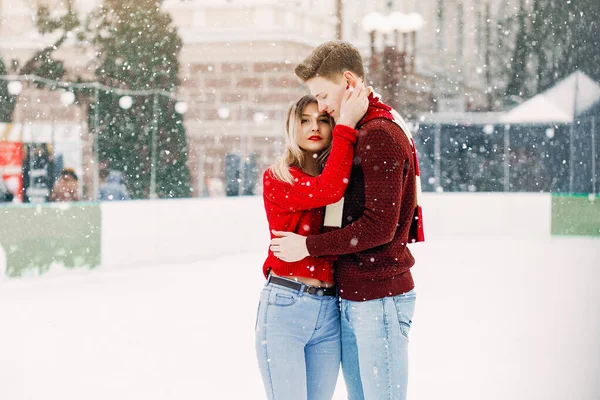 Casal bonito e amorosoem uma camisola vermelha em uma cidade de inverno — Fotografia de Stock