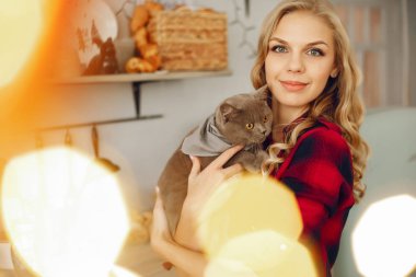 Güzel kız evde kediyle oynuyor.