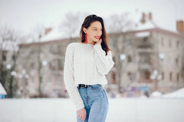 Młoda dziewczyna w białym swetrze stojąca w zimowym parku — Zdjęcie stockowe