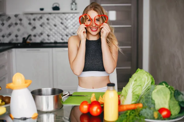 Σπορ κορίτσι σε μια κουζίνα με λαχανικά — Φωτογραφία Αρχείου