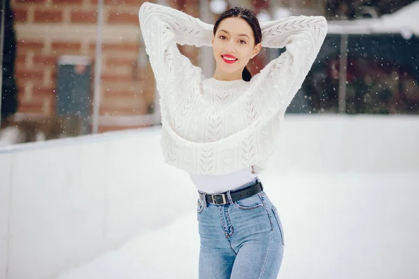 Jovem com uma camisola branca em pé em um parque de inverno — Fotografia de Stock