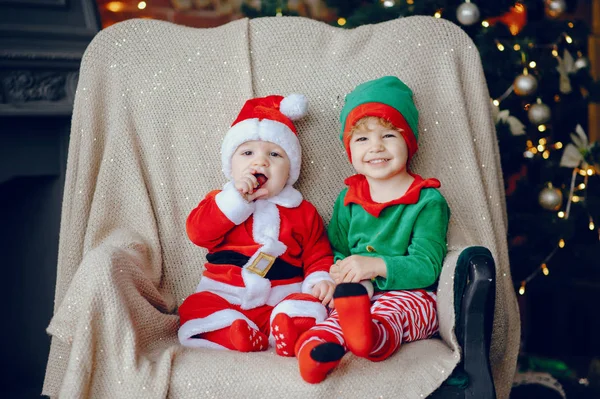 Cutte młodszych braci w domu w pobliżu dekoracji świątecznych — Zdjęcie stockowe