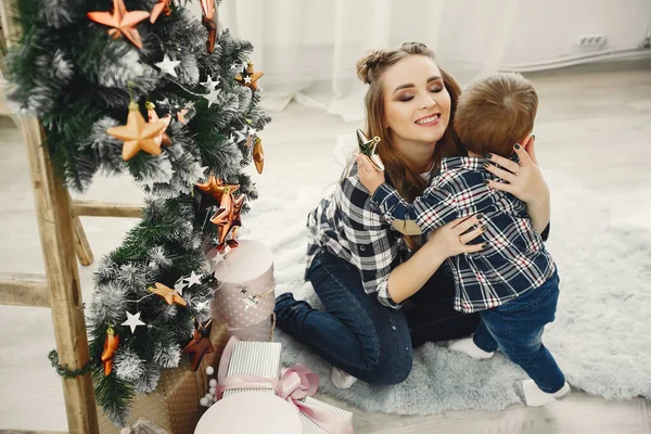 Linda familia sentada cerca del árbol de Navidad — Foto de Stock