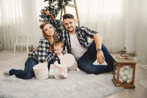 Nette Familie sitzt am Weihnachtsbaum — Stockfoto