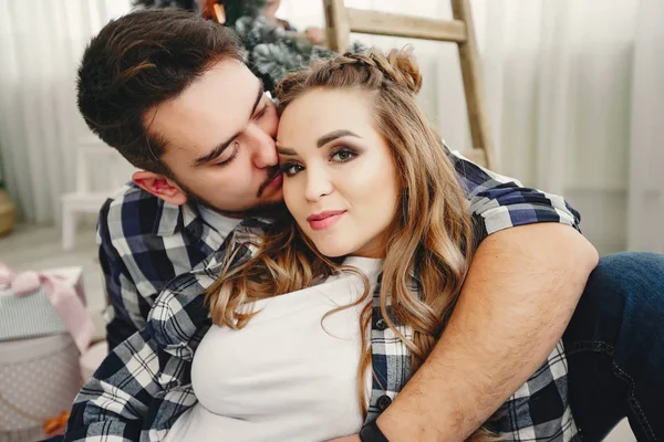 Linda familia sentada cerca del árbol de Navidad — Foto de Stock