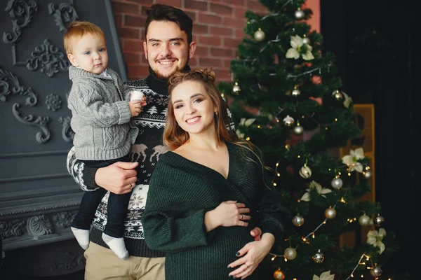 可爱的一家人坐在圣诞树旁 — 图库照片