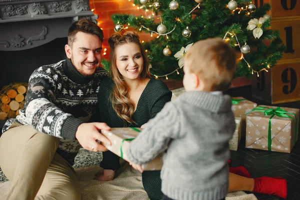 Linda familia sentada cerca del árbol de Navidad — Foto de Stock