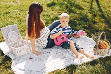 Anne ve oğlu yaz parkında oynuyorlar.