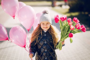 Parktaki küçük kız çimenlerde oynuyor.