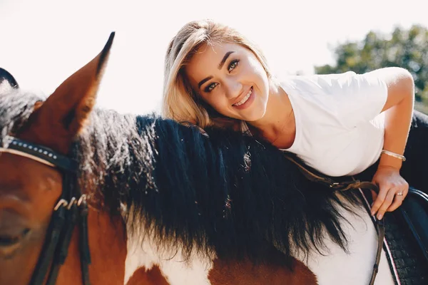 Элегантная девушка на ферме с лошадью — стоковое фото