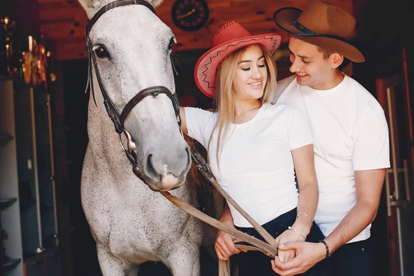 Belo casal passar o tempo com um cavalos — Fotografia de Stock