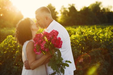 Güzel yetişkin bir çift yaz tarlasında vakit geçirir.
