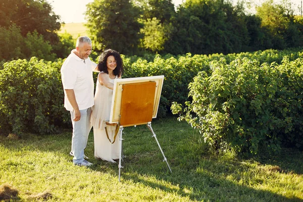 美しい大人のカップルは夏のフィールドで描く — ストック写真