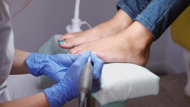 The nail technician is polishing nails on toes by a pedicure cutter — Stock Video