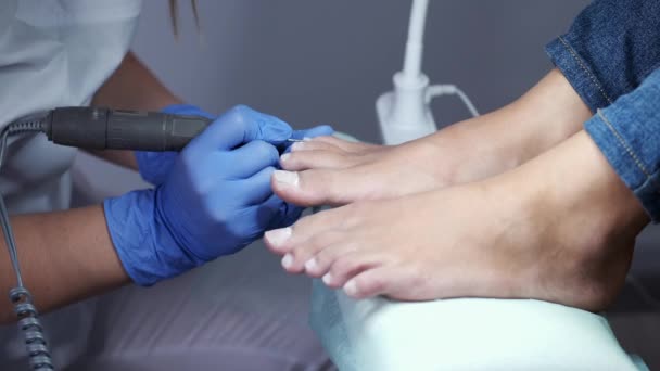 Technik paznokci poleruje paznokcie u stóp za pomocą noża do pedicure — Wideo stockowe