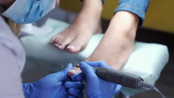 El maestro de la pedicura está puliendo clavos por un fresador — Vídeo de stock