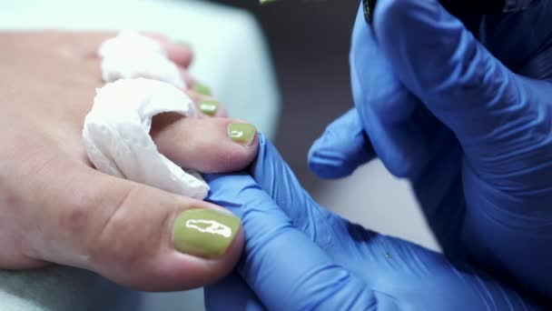 El maestro puliendo uñas con gel verde en un salón de belleza — Vídeo de stock