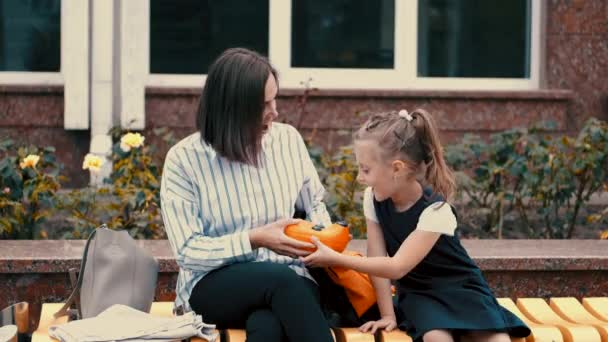 Madre europea y una hija pequeña están sentados en el banco — Vídeo de stock