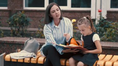 Anne ve küçük kızı defteri okuyorlar.