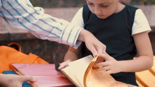 Мать и ученик переворачивают страницы блокнота — стоковое видео