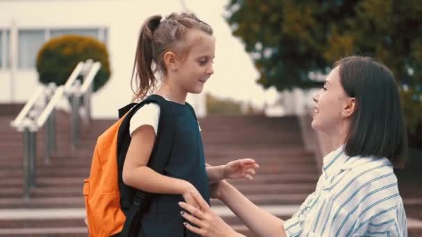 The pupil and her mother are embracing each other — Stock Video