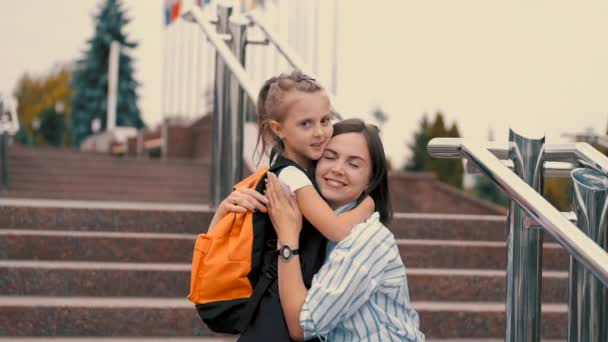 European mother and daughter are hugging each other after school — Stock Video