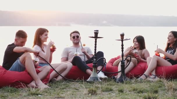 O círculo de amigos europeus está fumando narguilé e conversando — Vídeo de Stock