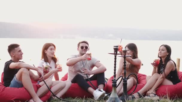 O círculo de amigos estão brindando com coquetéis e cachimbos de fumar no verão — Vídeo de Stock