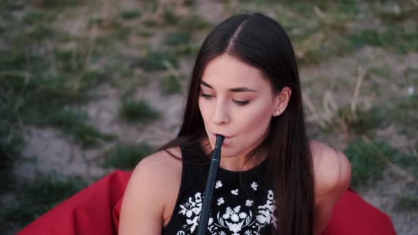 La joven europea está fumando una cachimba en la playa — Vídeos de Stock