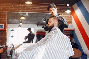 Berber dükkanında oturan şık bir adam.