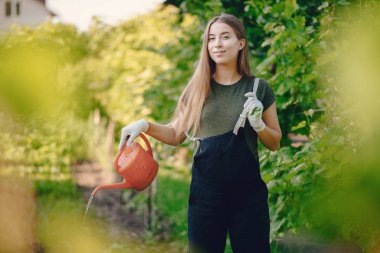 Güzel bir kadın evin yakınındaki bir bahçede çalışıyor.
