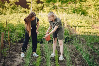 Güzel kadınlar evin yakınındaki bir bahçede çalışırlar.