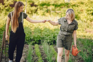 Güzel kadınlar evin yakınındaki bir bahçede çalışırlar.