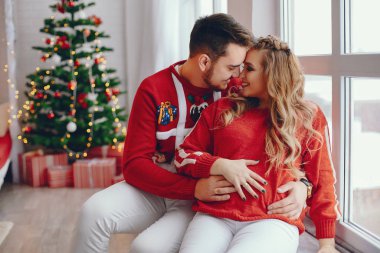Noel ağacının yanında oturan sevimli bir aile.
