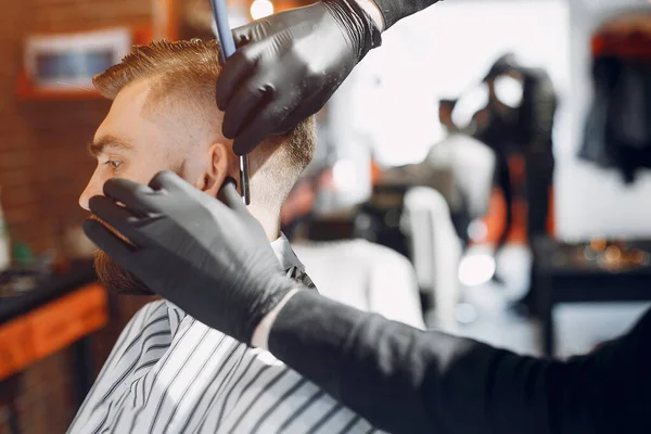 Stilvoller Mann sitzt in einem Friseurladen — Stockfoto