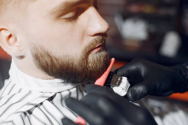 Elegante hombre sentado en una barbería — Foto de Stock