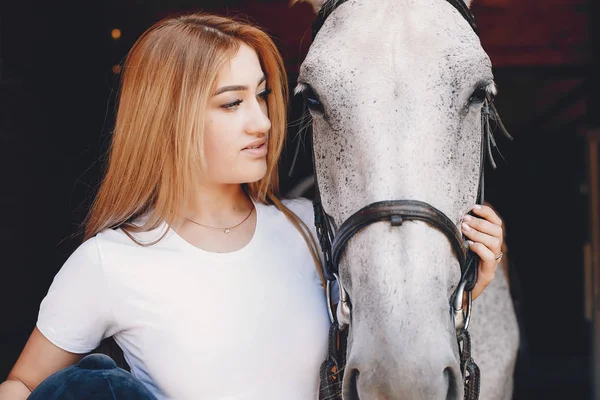 Menina elegante em uma fazenda wiith um cavalo — Fotografia de Stock