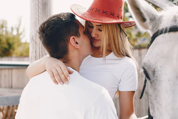 Beautiful couple spend time with a horses — Stock Photo, Image