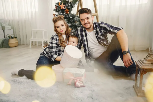 Linda familia sentada cerca del árbol de Navidad — Foto de Stock