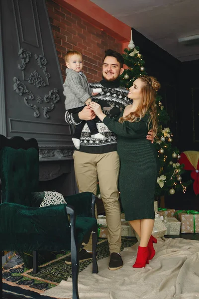 Cute family sitting near Christmas tree — Stock Photo, Image