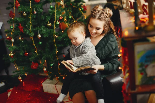 Linda familia sentada cerca del árbol de Navidad — Foto de Stock