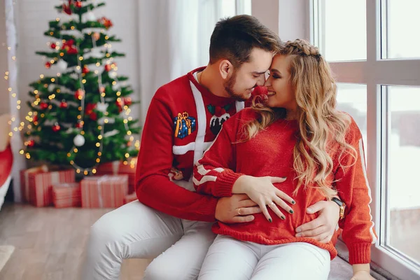 Nette Familie sitzt am Weihnachtsbaum — Stockfoto