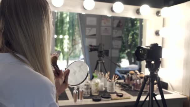 Una donna sta facendo il trucco davanti a uno specchio sulla macchina fotografica — Video Stock