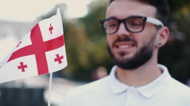 Öğrenci çubukta Gürcistan bayrağı sallıyor.