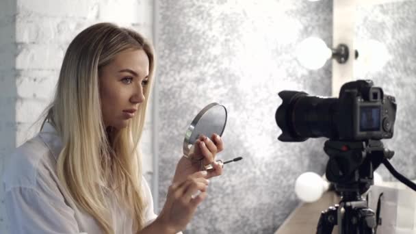 Una cámara está filmando un maquillador haciendo un tutorial de cambio de imagen — Vídeo de stock