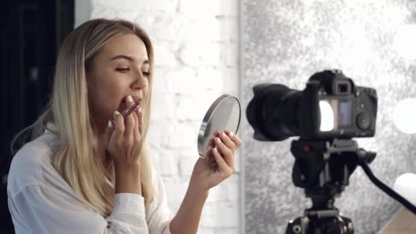 Una bonita artista de maquillaje está aplicando un delineador de labios en sus labios — Vídeos de Stock