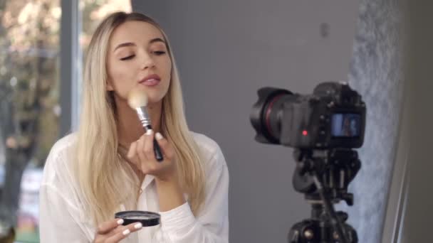 Europese blonde mooie make-up kunstenaar is het aanbrengen van poeder — Stockvideo